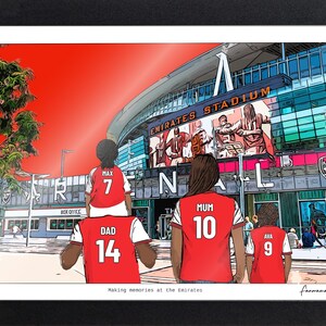 Personalised Arsenal family print in a black landscape frame, showing Dad 14 carrying Max 7 on his shoulders beside Mum 10 and Ava 9 at the Emirates Stadium.