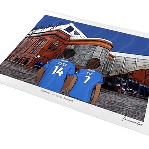 May include: A digital illustration print showing two people from behind wearing blue soccer jerseys with the names ALEX and SAM and numbers 14 and 7, standing in front of a red brick stadium. The text Together at Ibrox Stadium is printed below.