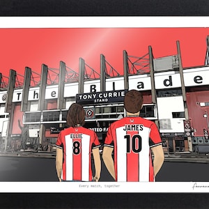 May include: A framed illustration of two individuals wearing red and white striped soccer jerseys with the names Ellie and James and numbers 8 and 10 on the back. They stand before the Tony Currie Stand at a stadium with the text Every match, together.