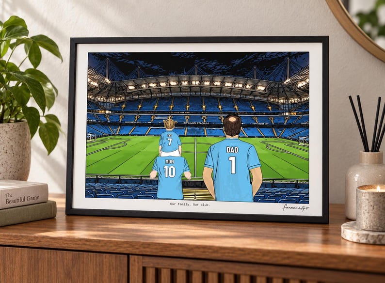 May include: A framed illustration of a soccer stadium with three people wearing light blue jerseys. One person has a child on their shoulders. The jerseys feature the text MUM 10, DAD 1, and a child's jersey with 7. The text Our family. Our club. is below.