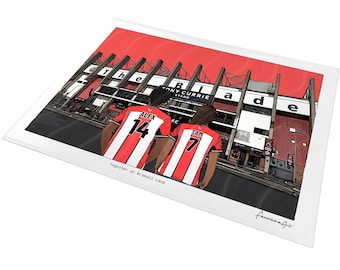 May include: A rectangular art print featuring a cartoon illustration of two people in red and white striped soccer jerseys with the names ALEX 14 and SAM 7, standing before the Tony Currie Stand at Bramall Lane, with the text Together at Bramall Lane.