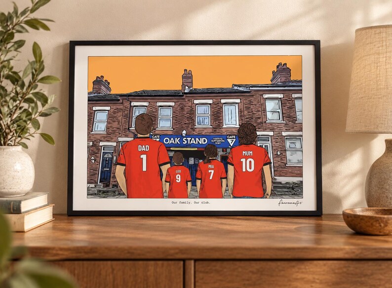 May include: A framed illustration depicting four people from behind, wearing red soccer jerseys with names and numbers. The jerseys read DAD 1, LEO 9, MIA 7, and MUM 10. They stand before a brick building labeled OAK STAND. The text Our family. Our club. is printed at the bottom.