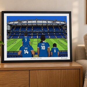 Puede incluir: Una ilustraci&oacute;n digital enmarcada de un estadio de f&uacute;tbol con cuatro figuras con camisetas azules en las gradas. Las camisetas llevan los nombres Max, Dad, Mum y Ava con los n&uacute;meros 7, 14, 10 y 9. El texto Our Family. Our club. aparece debajo.