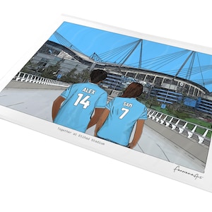 May include: A digital illustration print showing two individuals from behind, wearing light blue jerseys with the names ALEX 14 and SAM 7, standing before Etihad Stadium. The text Together at Etihad Stadium is printed below the figures.