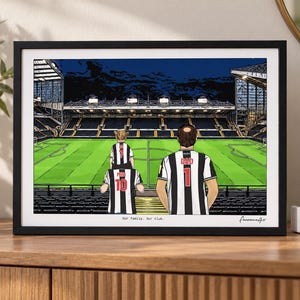 May include: A framed illustration of a soccer stadium with three people in black and white striped jerseys standing in the stands. The jerseys feature the text DAD, MUM, and numbers 1, 10, and 7. The text Our Family. Our club. is printed below.