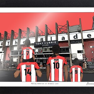 May include: A framed illustration of a family wearing red and white striped soccer jerseys with names and numbers on the back, standing before the Tony Currie Stand at Bramall Lane. The text reads 'The Blade', 'Tony Currie Stand', and 'Making memories at Bramall Lane'.