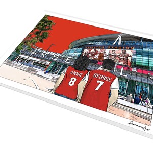 May include: A digital illustration of two people wearing red jerseys with the names "Annie 8" and "George 7" printed on the back. They are standing in front of the Emirates Stadium, home of Arsenal Football Club.