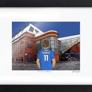 May include: A framed digital illustration of a person wearing a blue jersey with the name CHARLIE and the number 11 on the back, standing before a large red brick stadium. The text Our club. Our memories. is printed below the illustration.