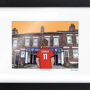 May include: A framed illustration of a person wearing a red jersey with the name CHARLIE and the number 11 on the back, standing before a brick building with blue signage labeled OAK, GATES F G and D E, under an orange sky.