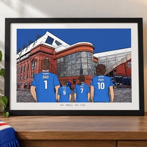 May include: A framed digital illustration of a family of four standing before a large red brick stadium. The family members wear blue soccer jerseys with names and numbers on the back. The text "Our family. Our club." is printed below the image.