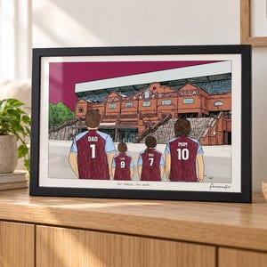 May include: A framed digital illustration of a family of four standing before the Aston Villa stadium. The figures wear claret and blue jerseys with the names DAD, LOU, PIA, and MUM and numbers 1, 9, 7, and 10. The text Our family. Our club. is printed below.