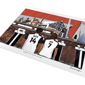 May include: A rectangular art print featuring a cartoon illustration of two people in white and black soccer jerseys with the names Alex 14 and Sam 7, standing before the Fulham Football Club stadium. The text reads Together at Craven Cottage.