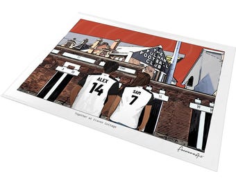 May include: A rectangular art print featuring a cartoon illustration of two people in white and black soccer jerseys with the names Alex 14 and Sam 7, standing before the Fulham Football Club stadium. The text reads Together at Craven Cottage.