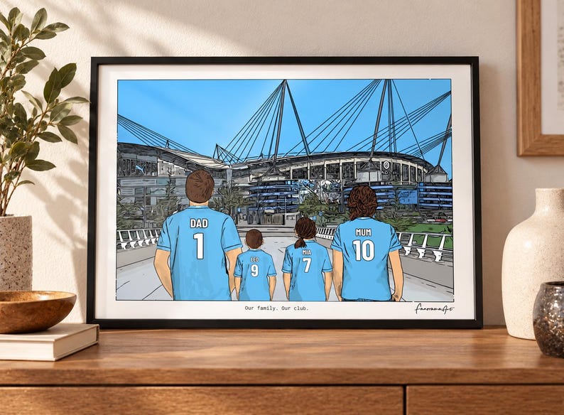 May include: A framed illustration of four people from behind wearing light blue soccer jerseys with names and numbers, standing before a large stadium. The text reads "Our family. Our club." and includes a signature in the bottom right corner.