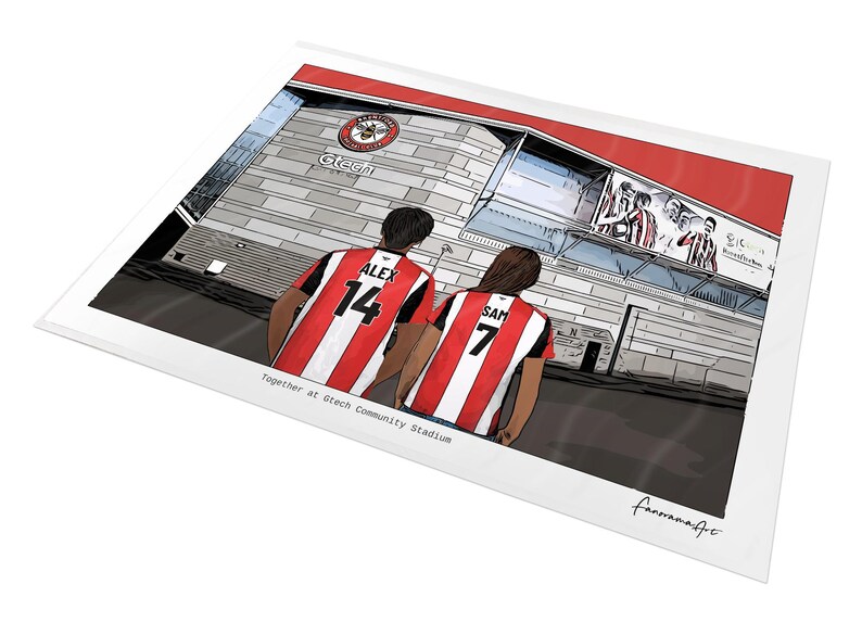 May include: A digital illustration print showing two individuals from behind wearing red and white striped football shirts with the names ALEX 14 and SAM 7, standing before the Gtech Community Stadium with the text Together at Gtech Community Stadium.