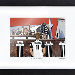 May include: A framed illustration of a person wearing a white and black jersey with the name CHARLIE and number 11 on the back, standing before The Fulham Football Club stadium building with a red sky and brick architecture.