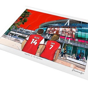 A4 unframed personalised Arsenal print showing Alex 14 and Sam 7 in red shirts facing the Emirates Stadium, displayed at an angle on a white background.