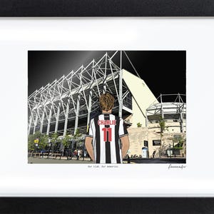 May include: A framed illustration of a person seen from behind, wearing a black and white striped jersey with the name CHARLIE and the number 11 in red. The person faces a large stadium structure. The text Our club. Our memories. is printed below.