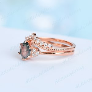 May include: A rose gold engagement ring set with a green and brown agate gemstone and a delicate band of pave set diamonds.