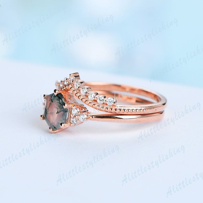 May include: A rose gold engagement ring set with a green and brown agate gemstone and a delicate band of pave set diamonds.