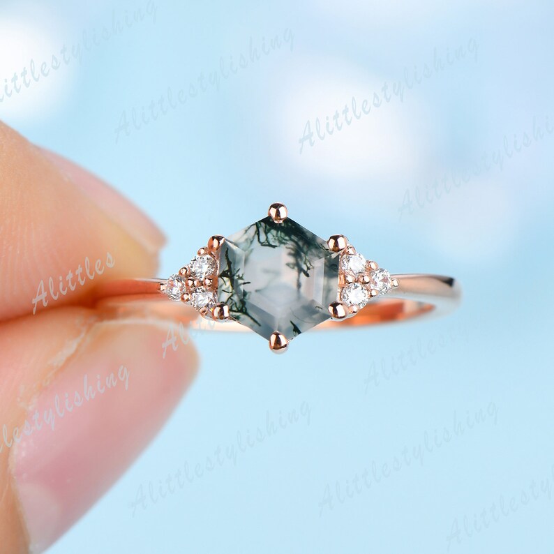 May include: Rose gold ring with a hexagonal green moss agate gemstone and small clear diamonds on the band.