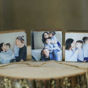 Peut inclure: Trois blocs de bois avec des photos imprimées d'une famille avec deux enfants. Les photos montrent la famille dans différentes poses, notamment en train de se câliner et de jouer.