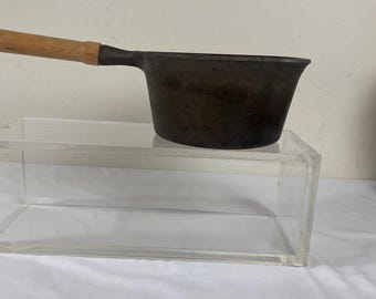 A vintage Cast Iron two quart sauce pot with wooden removable handle