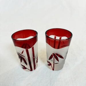 May include: A handmade, ceramic mug with a speckled, cream-colored glaze. The mug features a wide, rounded body and a sturdy handle. The interior is a darker, contrasting shade. The mug is approximately 4 inches tall.
