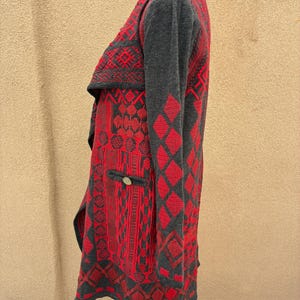 Puede incluir: C&aacute;rdigan estampado en rojo y gris con cuello chal. El c&aacute;rdigan presenta un dise&ntilde;o geom&eacute;trico con rombos y otras formas. Tiene un peque&ntilde;o bolsillo con un bot&oacute;n decorativo.