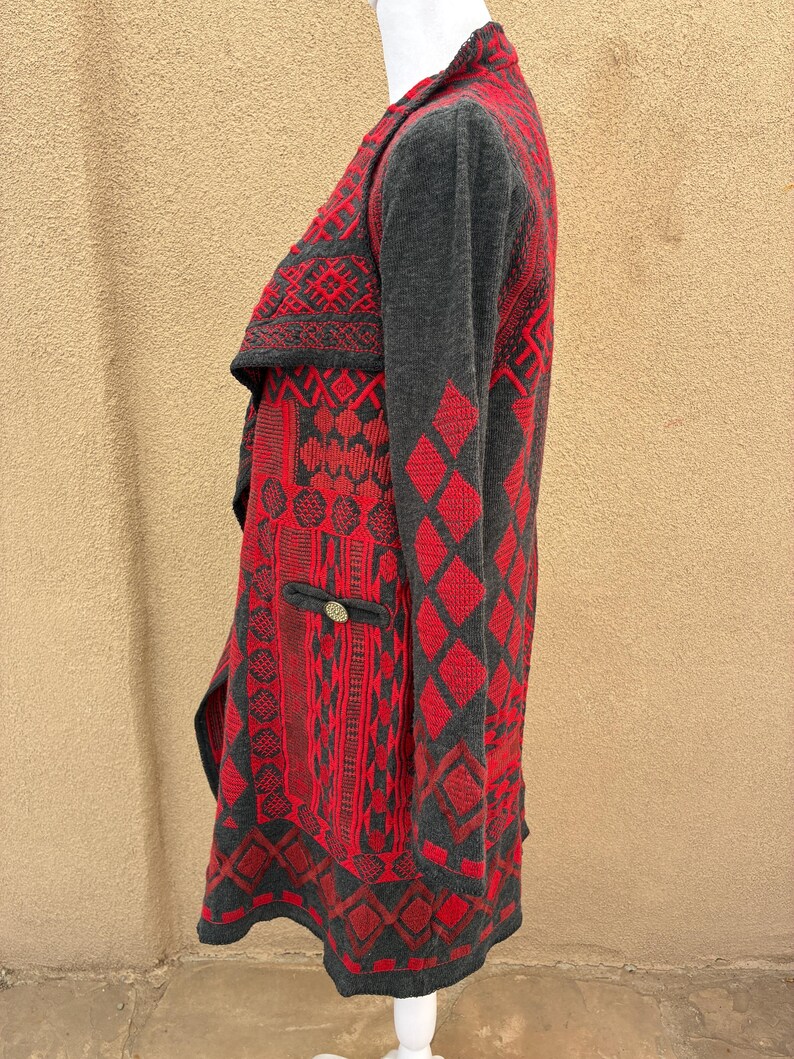 Puede incluir: C&aacute;rdigan estampado en rojo y gris con cuello chal. El c&aacute;rdigan presenta un dise&ntilde;o geom&eacute;trico con rombos y otras formas. Tiene un peque&ntilde;o bolsillo con un bot&oacute;n decorativo.