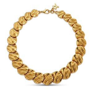 May include: A gold-toned necklace composed of a series of circular, textured links with a wavy, rippled surface pattern. The necklace features a lobster claw clasp and a small, dangling letter M charm near the closure, creating a continuous circular design.