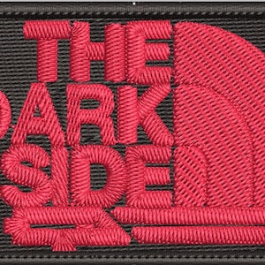 May include: A black and red embroidered patch with the text "THE DARK SIDE" and a red North Face logo.