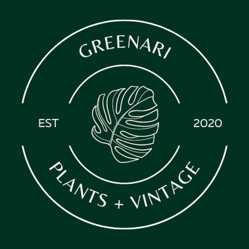 May include: A dark green circular logo with white text and a white outline of a monstera leaf. The text reads "GREENARI" at the top, "PLANTS + VINTAGE" at the bottom, and "EST 2020" on the sides.
