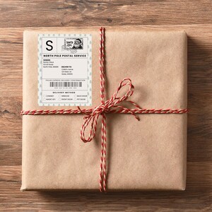 Kraft-wrapped Christmas present tied with festive red twine featuring a personalized North Pole delivery sticker. A charming way to bring Santa’s magic to holiday gift-giving.