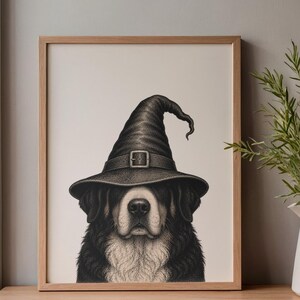 May include: A framed black and white illustration of a Bernese Mountain Dog wearing a tall, pointed witch hat with a buckle. The dog has a dark coat with a white chest and muzzle, rendered in a detailed stippled art style within a light wood frame.