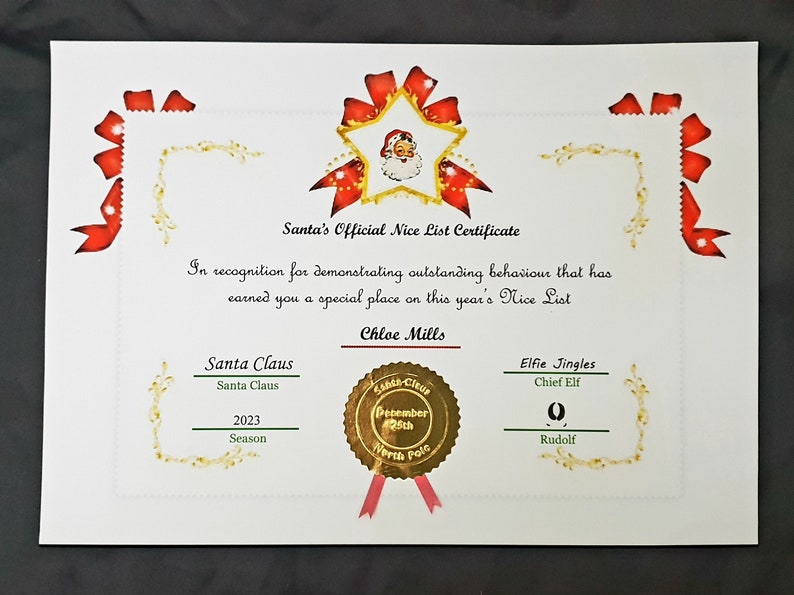 May include: A red and gold certificate with a star and Santa Claus image. The certificate reads "Santa's Official Nice List Certificate" and "In recognition for demonstrating outstanding behaviour that has earned you a special place on this year's Nice List." The certificate is signed by Santa Claus and Elfie Jingles, Chief Elf. The date is December 25th, 2023.