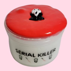 May include: A white container with red slime and a Ghostface mask on top. The container has the text "SERIAL KILLER" printed on the front.