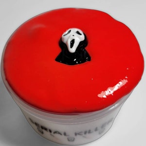 May include: Red slime with a white ghost mask on top in a clear plastic container with the words "Serial Killer" written on the bottom.