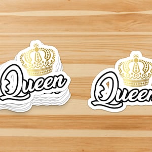 May include: Two white stickers with black text that says "Queen" and a gold crown on top.