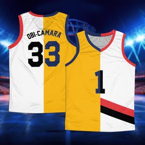 May include: A white and yellow basketball jersey with the name "OBI-CAMARA" and the number "33" on the back. The jersey is split down the middle, with the left side being white and the right side being yellow. The jersey has a red and black stripe on the front.