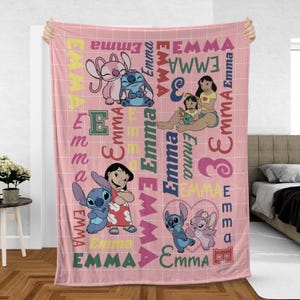 May include: Pink fleece blanket featuring cartoon characters and the name "Emma" in various fonts and colors. The blanket has a grid pattern and includes images of Stitch and Angel.