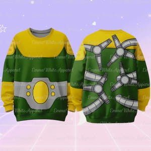 Puede incluir: Una sudadera verde y amarilla con un dise&ntilde;o de dibujos animados. La parte delantera presenta un &oacute;valo amarillo y detalles en gris, mientras que la parte trasera muestra m&uacute;ltiples brazos mec&aacute;nicos grises. El texto "Emma White Apparel" est&aacute; impreso en la sudadera.