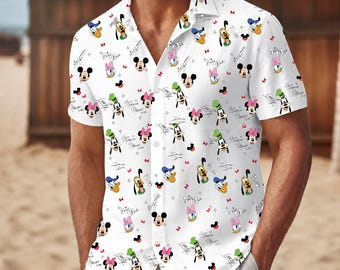 Op de afbeelding: Een wit overhemd met korte mouwen en knoopsluiting, voorzien van een all-over print van diverse stripfiguren zoals Mickey Mouse, Minnie Mouse, Goofy en Donald Duck, afgewisseld met kleine rode strikjes en cursieve handtekeningen.