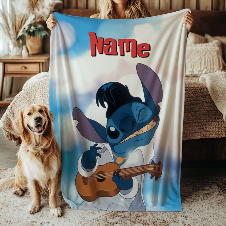 May include: A blue and white blanket featuring a cartoon character playing a ukulele. The character is blue with large ears and is wearing a white outfit. The word "Name" is printed in red at the top of the blanket.