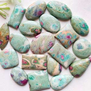 May include: A collection of 15 green, pink, and white cabochon gemstones with a variety of shapes and sizes. The stones have a speckled pattern and are perfect for jewelry making.
