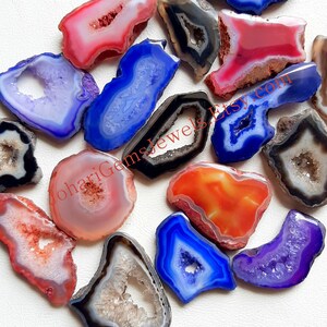May include: Assortment of agate slices with various colors and patterns, including blue, red, orange, purple, and black. The agate slices have a natural, raw look and are perfect for jewelry making or home decor.
