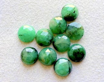 May include: A collection of nine round, faceted green gemstones. Each stone features a circular cut with multiple flat, polished surfaces that reflect light, displaying varying shades of deep forest green and lighter emerald tones throughout.