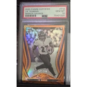 May include: A 2020 Panini Certified J.K. Dobbins Mirror Orange football card. The card features a player in a Baltimore Ravens uniform, with the number 27. The card is graded GEM MT 10, with the serial number 162/199.