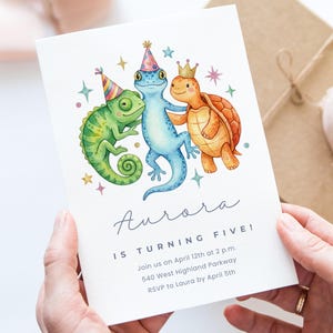 May include: A white invitation card with a watercolor illustration of a green chameleon, blue gecko, and orange turtle wearing party hats and a crown. The text reads "Aurora is turning five!" with event details.