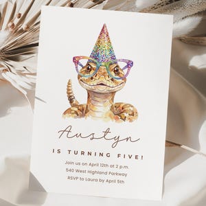 Op de afbeelding: Een verjaardagsuitnodiging met een aquarel illustratie van een slang met een feesthoed en bril. De uitnodiging luidt "Austyn wordt vijf!" met evenementdetails hieronder.